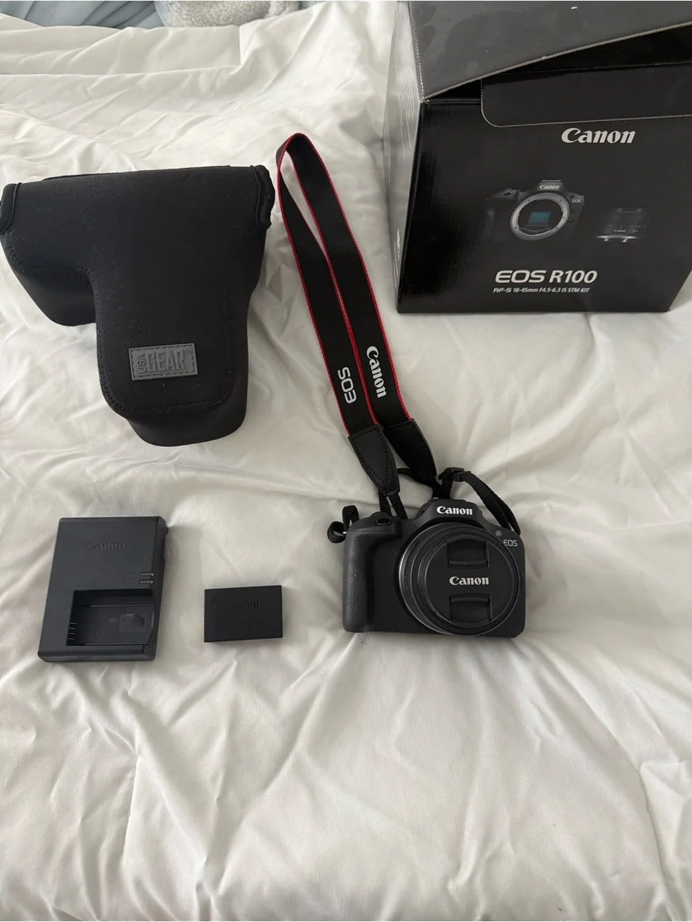 Canon EOS R100 Compact Mirrorless Camera with Red-Trim Strap – Black